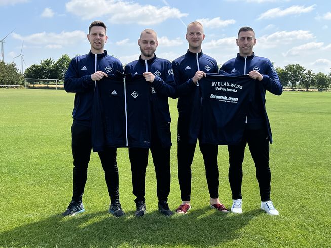 Vier Mitglieder des SV Blau-Weiss 55 Schortewitz e.V. präsentieren stolz ihre neuen Trainingsanzüge.