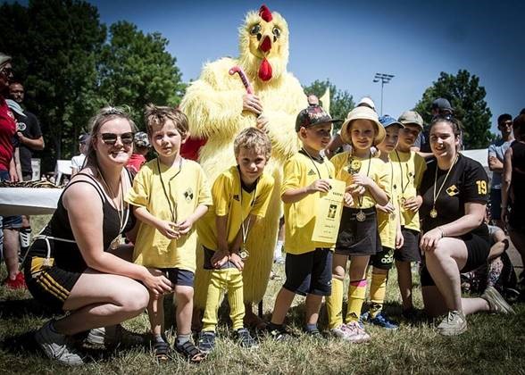 Gruppenfoto einiger Mitglieder des Köthener Hockeyvereins CHC 02 mit Hühner-Maskottchen.